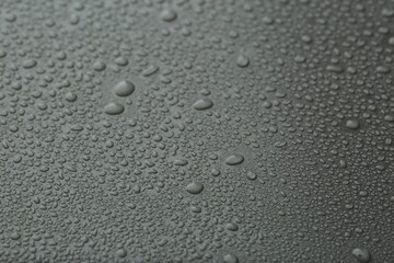 Many water drops on grey background, closeup
