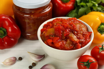 Delicious lecho and fresh ingredients on white wooden table, closeup