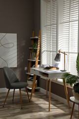 Comfortable writer's workplace interior with typewriter on desk in front of window