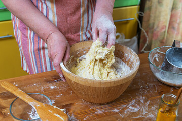 Women's hands knead the dough in the home kitchen. Close-up.