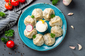 Manty with beef and sour cream on grey table top view