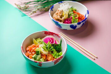 Poke with salmon and poke with chicken on bowls selective focus