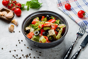 Greek salad with feta and vegetables on grey table