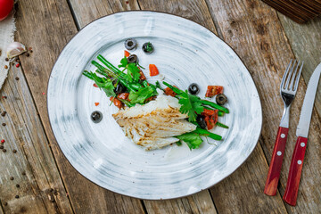 morue grill with green beans on plate on wooden table top view
