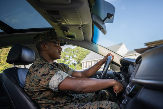 Marine service member arrives home in his car and walks into his house.