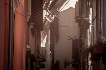Selective blur on the wooden shutters of houses in Typical mediterranean old narrow street with...
