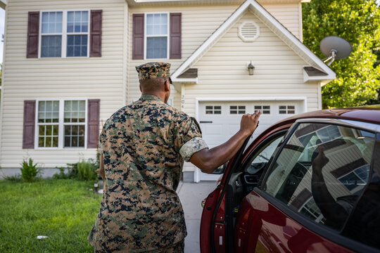Marine service member arrives home in his car and walks into his house.