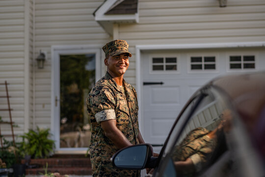 Marine service member arrives home in his car and walks into his house.