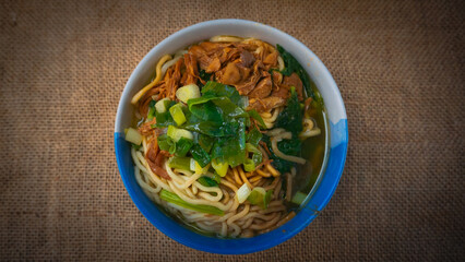 a bowl of chicken noodles (mie ayam) with brown cloth. One of the foods that are sold in street stalls