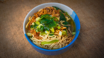 a bowl of chicken noodles (mie ayam) with brown cloth. One of the foods that are sold in street stalls
