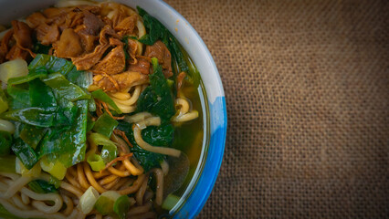 a bowl of chicken noodles (mie ayam) with brown cloth. One of the foods that are sold in street...