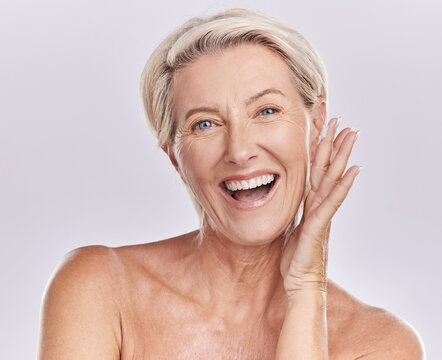 Portrait of a happy woman showing healthy skin with smile, advertising beauty skin care cosmetics and health wellness on grey studio background. Portrait of face of senior model doing self care