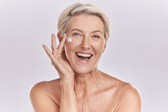 Skin, Skincare Or Collagen Lotion With Old Woman Posing With A Smile With Her Cosmetics And Product. Senior Female, Facial Cream And Sunscreen For A Healthy Face And Beauty Model Wellness Portrait.