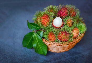 Fresh and ripe rambutan sweet tropical fruit peeled rambutan with leaf on basket, rambutan fruit harvest from the garden rambutan tree