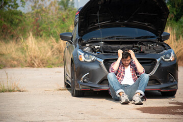 Man fixing a car problem after vehicle breakdown on the road