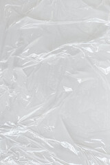 White transparent crumpled and creased plastic poster texture background. wet plastic wrap on the...