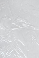 White transparent crumpled and creased plastic poster texture background. wet plastic wrap on the white background