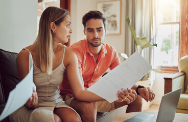 Unhappy, stressed and upset couple paying bills or debt online on with a laptop at home getting angry, planning budget. Young man and woman having a dispute over finance, savings and increasing tax