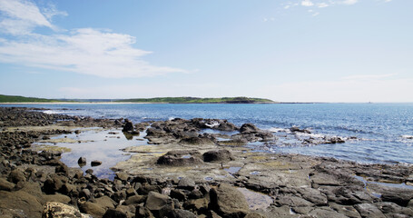 Fototapeta na wymiar Sea over the rock beach in sunny day