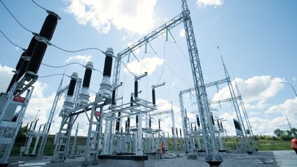 Many high voltage electrical insulators in power substation against blue sky background