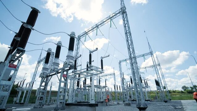 Many high voltage electrical insulators in power substation against blue sky background