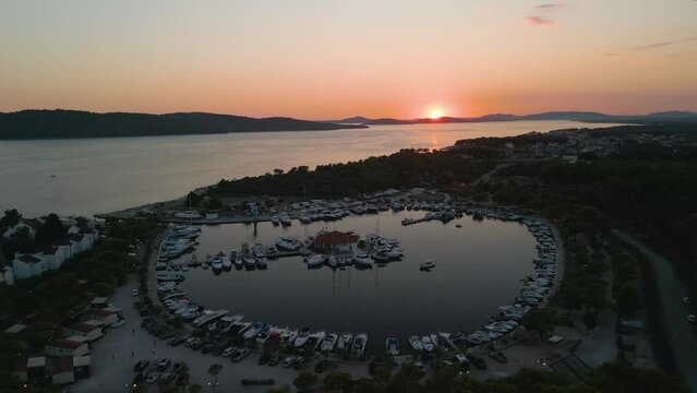 Aerial view of solaris coastline croatia town on Adriatic Sea, luxury sail boat moored in port harbour at sunset, drone reveal stunning seascape 