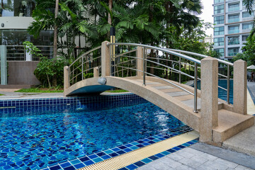 Bridge over the blue water pool at the resort in the hotel.