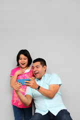 Hispanic Latino dad and daughter play, dance, surprise, enjoy, taking selfies using the cell phone spending quality family time
