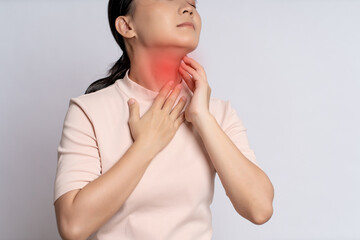 Asian woman was sick with sore throat and touching neck with red spot, standing isolated on white background.