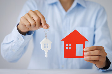 Hands holding a  house model. Housing industry mortgage plan and residential tax saving strategy, mortgage, investment, real estate and property concept