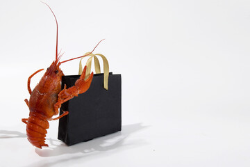 Boiled red crayfish lobsters with black bags with Black Friday purchases, funny photo for...