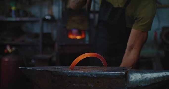 blacksmith is forging hot metal detail on anvil, use big hammer, closeup view, 4K, Prores