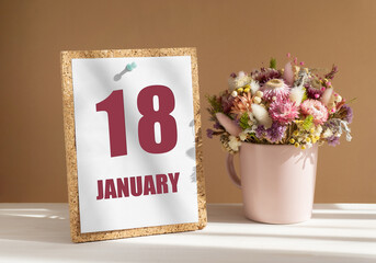 january 18. 18th day of month, calendar date.Bouquet of dead wood in pink mug on desktop.Cork board with calendar sheet on white-beige background. Concept of day of year, time planner, winter month