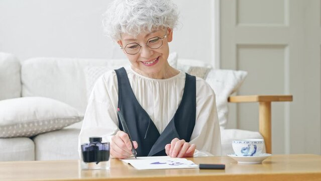インクで文字を書くシニア女性
