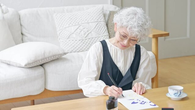 インクで文字を書くシニア女性