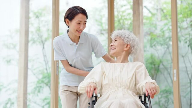 車椅子のシニア女性と介護士