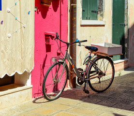 Fototapeta na wymiar Bicycles parked in front of a colorful house in Burano island, Italy.