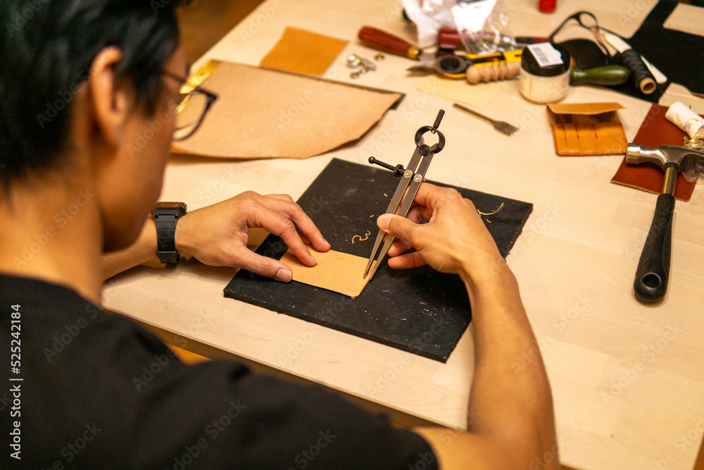 Wall mural craftsman measures leather