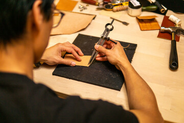 Craftsman Measures Leather Piece With Great Care