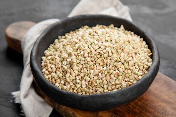 Raw green buckwheat on dark background. Food ingredients.