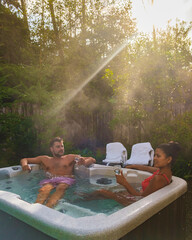 couple in a hot tub bath in the rain forest of Vancouver Island, men and women in a jacuzzi in the...