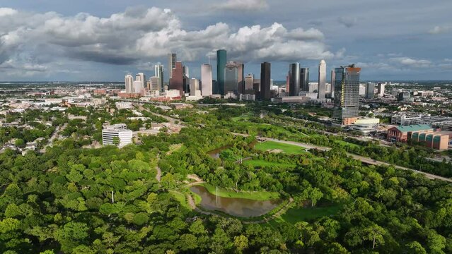 Aerial view over a park towards the city center of Houston city, golden hour in USA