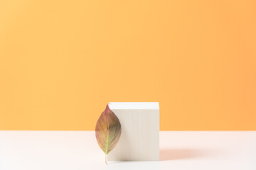 Wood podium on orange background with colorful autumn leaf.  Concept scene stage showcase, product,...