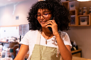 Black seller speaking on smartphone