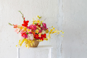 autumn bouquet with red and yellow flowers in ceramic vase on white  background