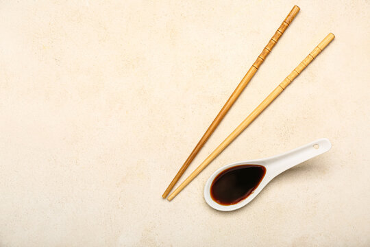 Spoon Of Soy Sauce And Chopsticks On Light Background