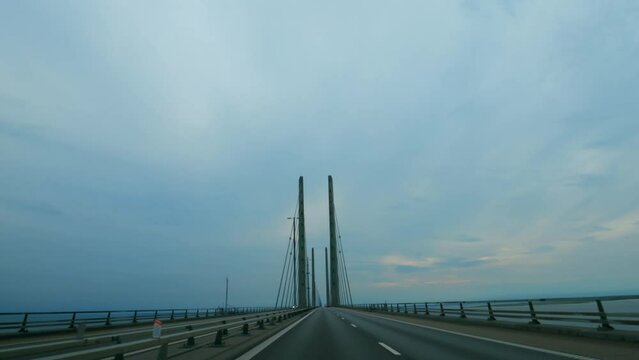 Driving on the Øresund Bridge spanning between Denmark and Sweden. Large suspension bridge.
