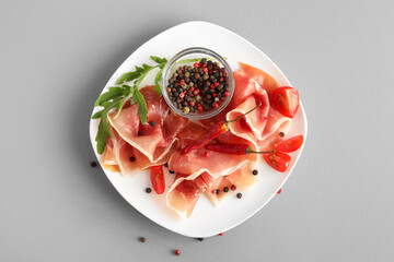 Plate of delicious jamon with peppercorns on light background