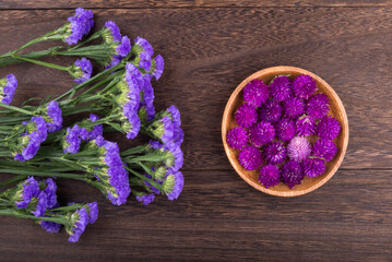 Obraz na płótnie Canvas 木のテーブルの上の紫のハナハマサジと千日紅の花