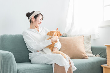 家で猫と遊ぶ日本人女性（嫌がる・抱っこ嫌い）
